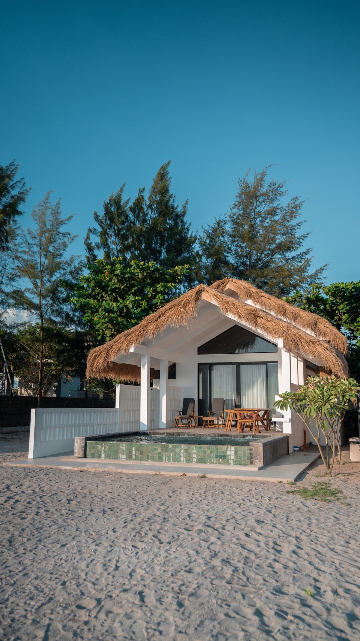 Costa Sambali villa exterior with thatched roof and private pool on the beach