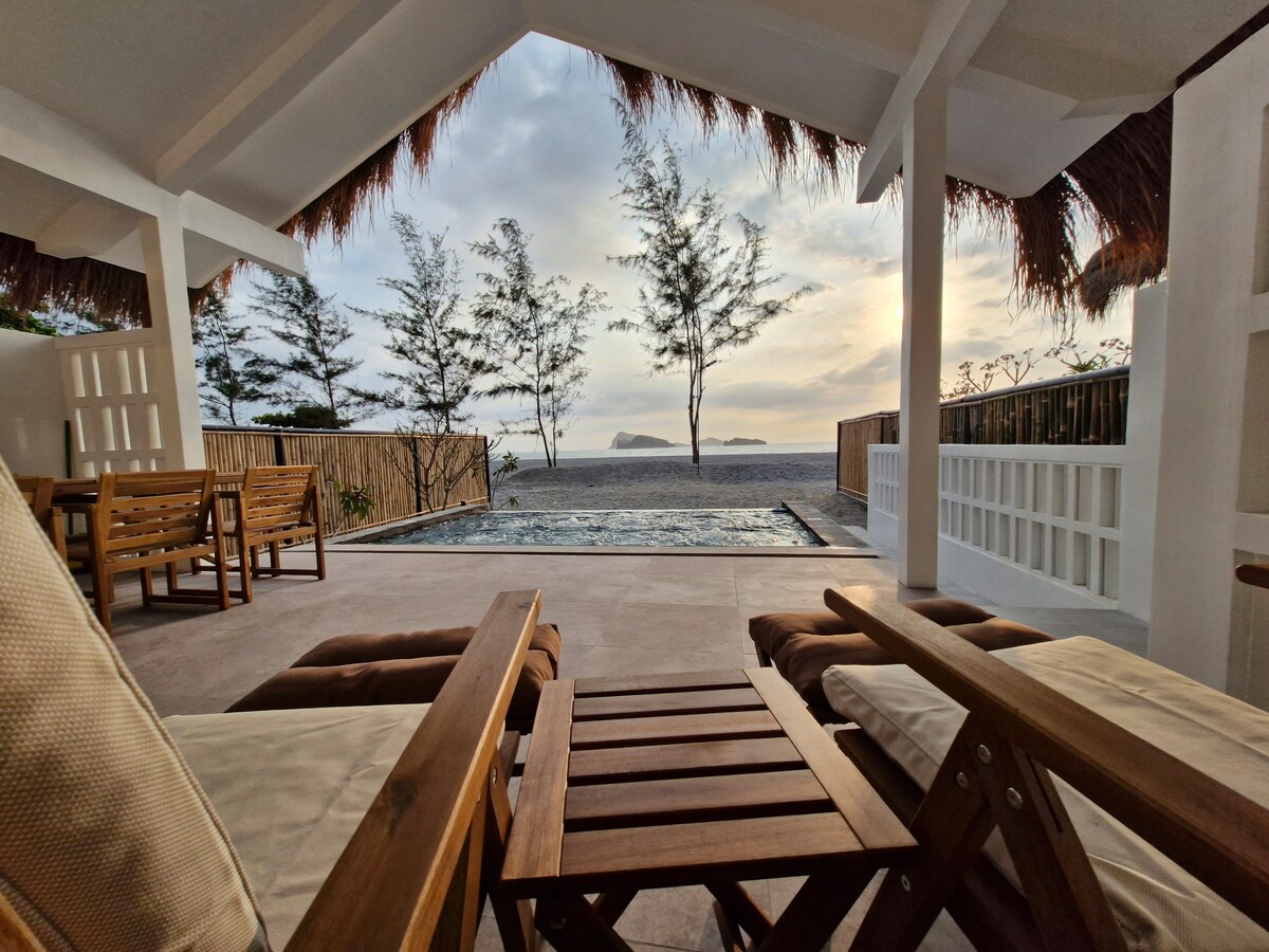 Villa terrace with lounge chairs overlooking pool, beach, and ocean